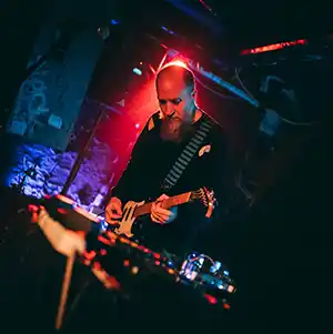 Photo de l'artiste AIDAN BAKER sur scène avec sa guitare