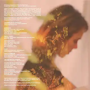 Photo de l'artiste Catherine Graindorge tête penchée de profil devant un rideau en voile