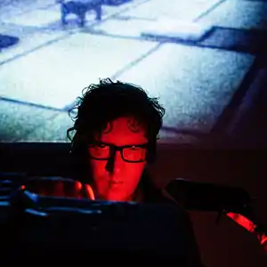 Photo de l'artiste HANNO LEICHTMANN avec un eclairage rouge sur fond bleu