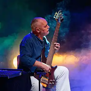 Photo de LAURENT PERNICE assis sur scène avec sa guitare électrique