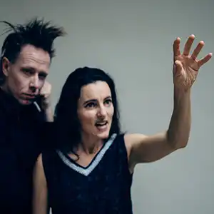 Photo des deux artistes STIAN WESTERHUS MAJA S.K. RATKJE, un homme tout en noir et une femme brune qui lève la main gauche