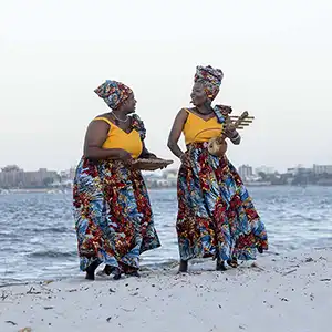 Photo des artistes de THE ZAWOSE QUEENS sur la plage avec leurs instruments