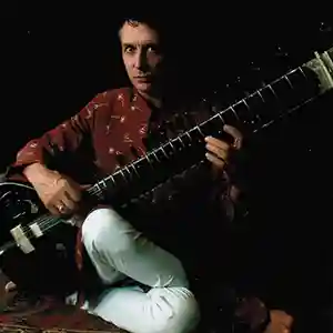 Photo de l'artiste Al Gromer Khan assis au sol joaunt du sitar indien
