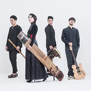 Photo du groupe coréen Black String, quatre musiciens avec leurs instruiments dont la joueuse de geomungo (cithare à 6 cordes), Yoon-Jeong Heo. Le groupe présente aussi le daegum (flûte en roseau) et la guitare électrique.