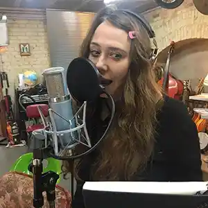 Photo de l'artiste Danielle de Picciotto dans un studio d'enregistrement en train de chanter devant un micro