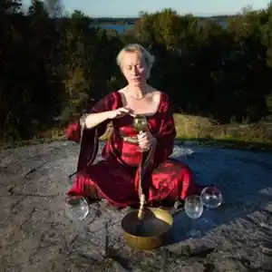 Photo de l'artiste suédoise Karin Höghielm jouant du verre à vin en pleine nature