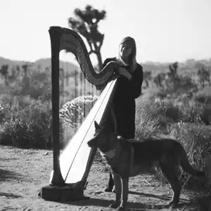 Photo de l'artiste Mary Lattimore en plein air avec sa harpe et son chien