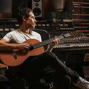 Photo du compositeur Marc Wilkinson dans studio d'enregistrement en train de jouer sur une guitare classique
