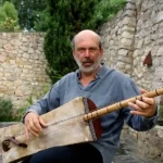 Photo de l'artiste Stephan Micus avec son instrument