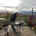 Photo de l'artiste Laurent Pernice avec ses instruments en plein air