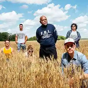 Photo du groupe Tonerre avec l'artiste Bony Bikaye au centre en pleine nature dans un champ de blé
