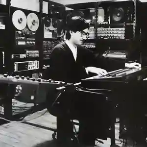 Photo de l'artiste japonais Yoshiaki Ochi devant ses machines et ses instruments