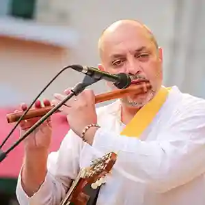 Photo de l'artiste Dominique Beven sur scène en train de jouer avec un instrument à vent.
