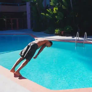 Pochette de l'album "The Abyss" par Malcolm Pardon. Une silhouette s’avance vers l’eau d'une piscine, prête à plonger dans l’inconnu.