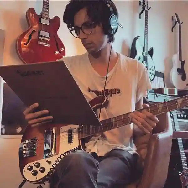 Photo de François Merlin dans son home studio tenant à la main son album vinyle "Les Magnifiques"